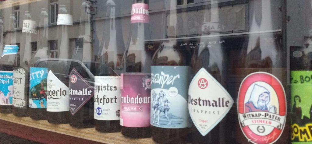 Rows of beer bottles in a shop window display in Bruges