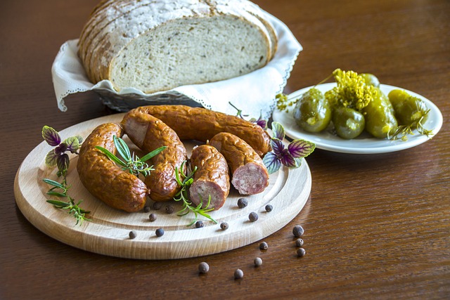 Table laid with sausages, sliced bread and gherkins