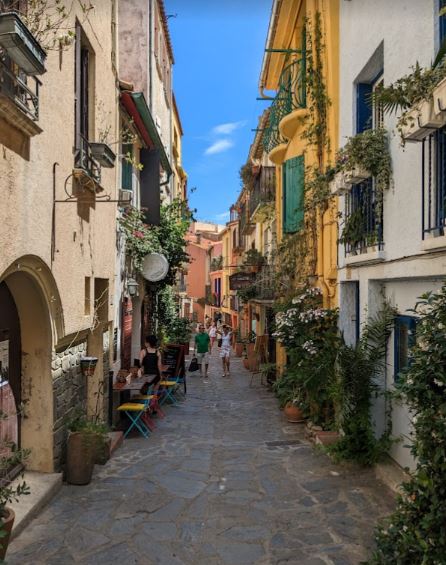 A street vista in Collioure with colourful buildings and green plants on the balconies