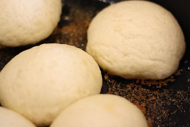 Round steamed buns frying in a pan