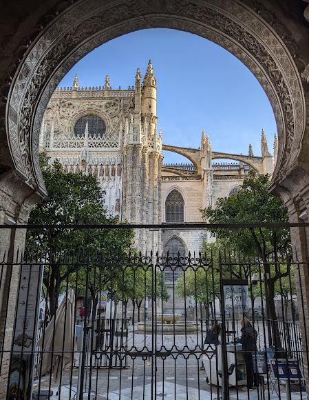 A view of Seville's Cathedral from behind a keyhole shaped arch