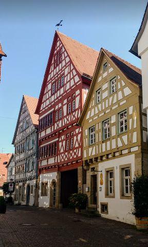 Three colourful half-timbered houses under a blue sky